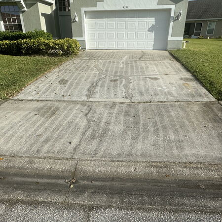 Dirty driveway with lines on it from bad pressure washing job