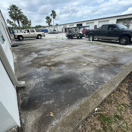 A photo of a commercial dirty parking lot with warehouses surrou