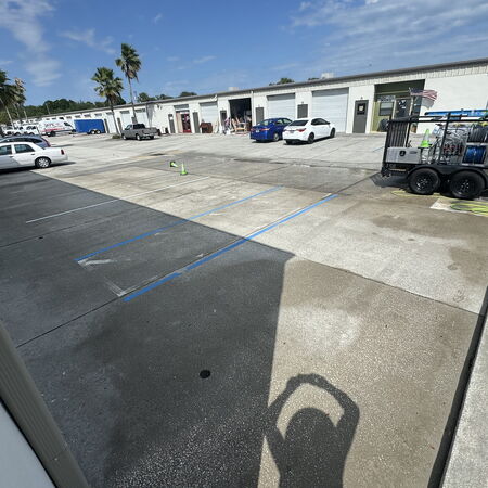 Clean commercial parking lot with warehouses surrounding