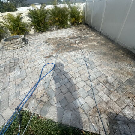 Dirty back patio with fire pit and vinyl fence surrounding 