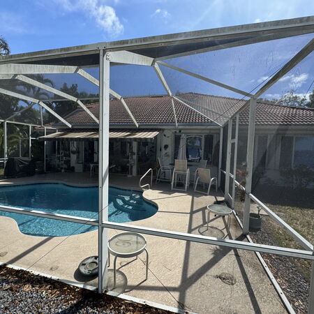 Mold covered screen enclosure over pool before washing